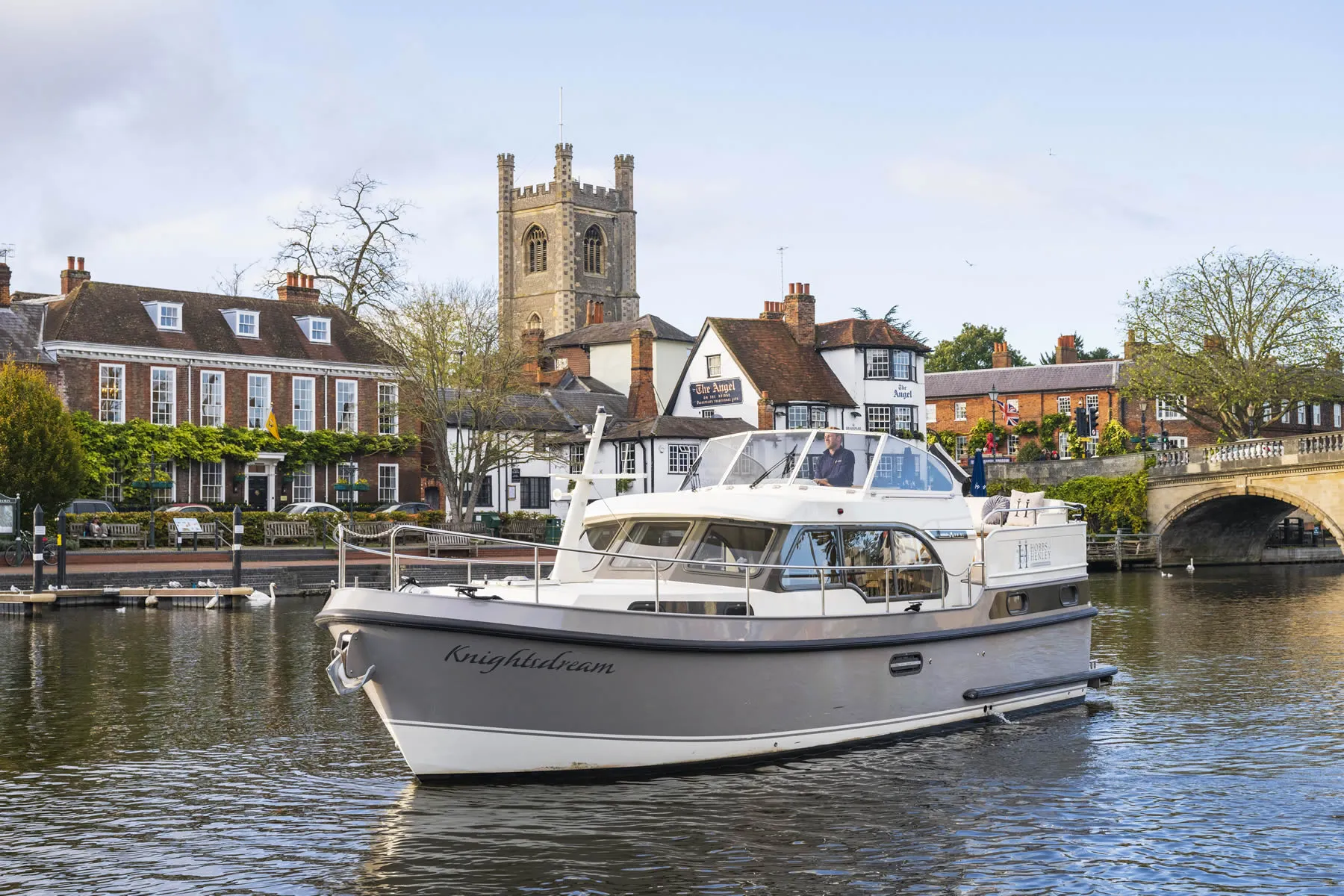 Hobbs of Henley boat Knightsdream being skippered by team member Lewis cruising along the river thames passing the famous pub 'The Angel' on the bridge